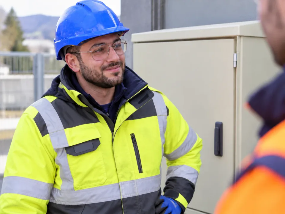 Spécialiste électro avec vêtements de protection en échange d'un collègue
